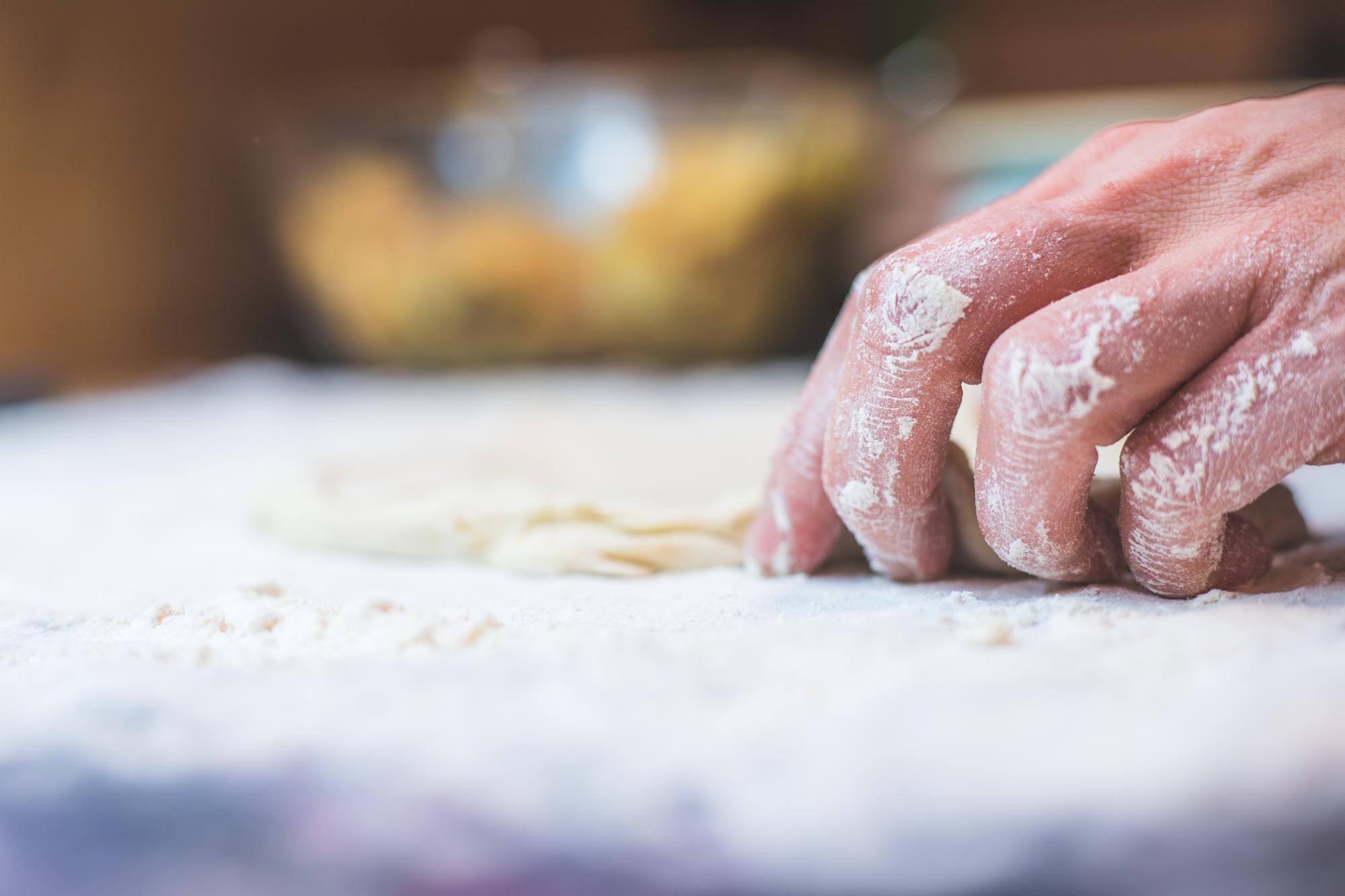 Mani dell'insegnante mentre lavorano l'impasto