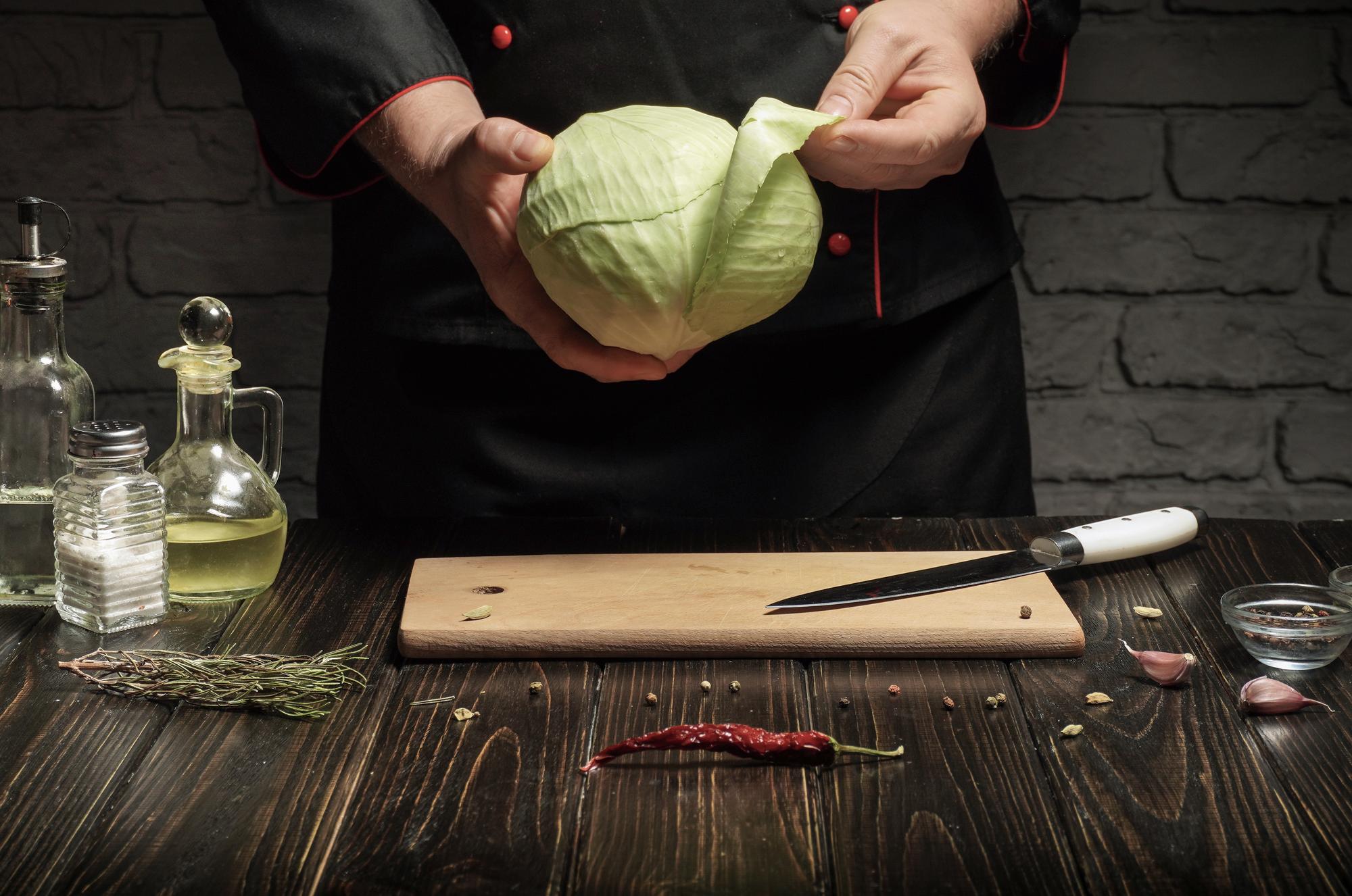 Chef in cucina con ingredienti disposti su tavolo
